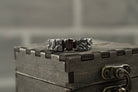 Volcanic textured sterling silver ring on a wooden box, side view