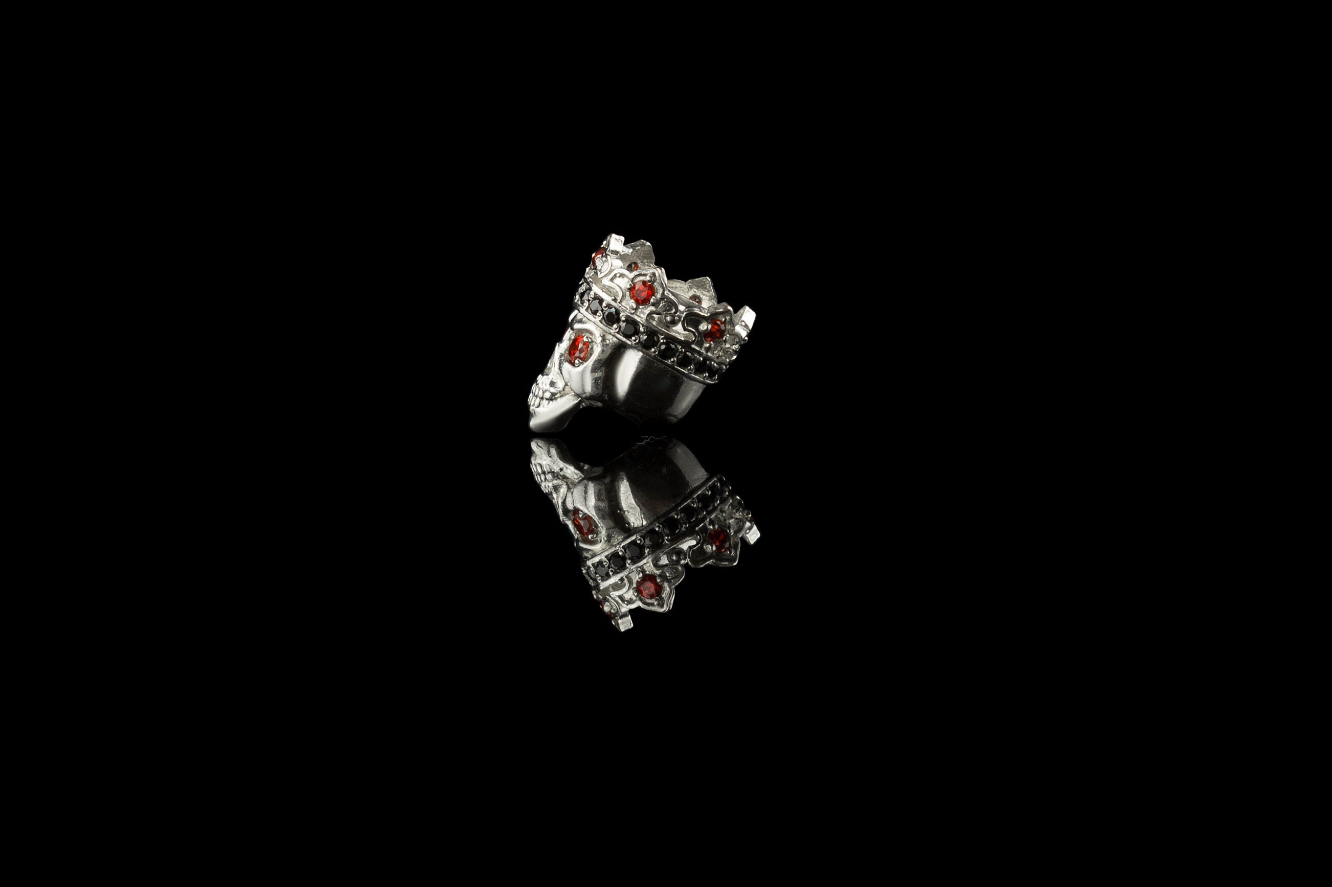 Side view of the sterling silver crowned skull charm bead with red and black cubic zirconia