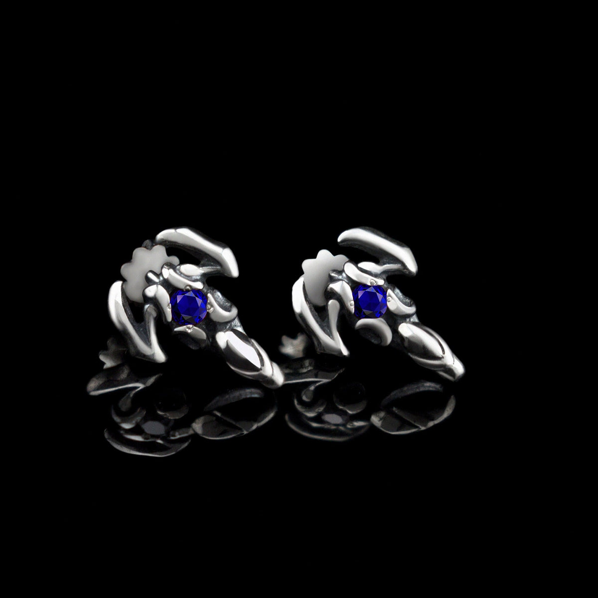 Silver scorpion stud earrings with dark blue cubic zirconia