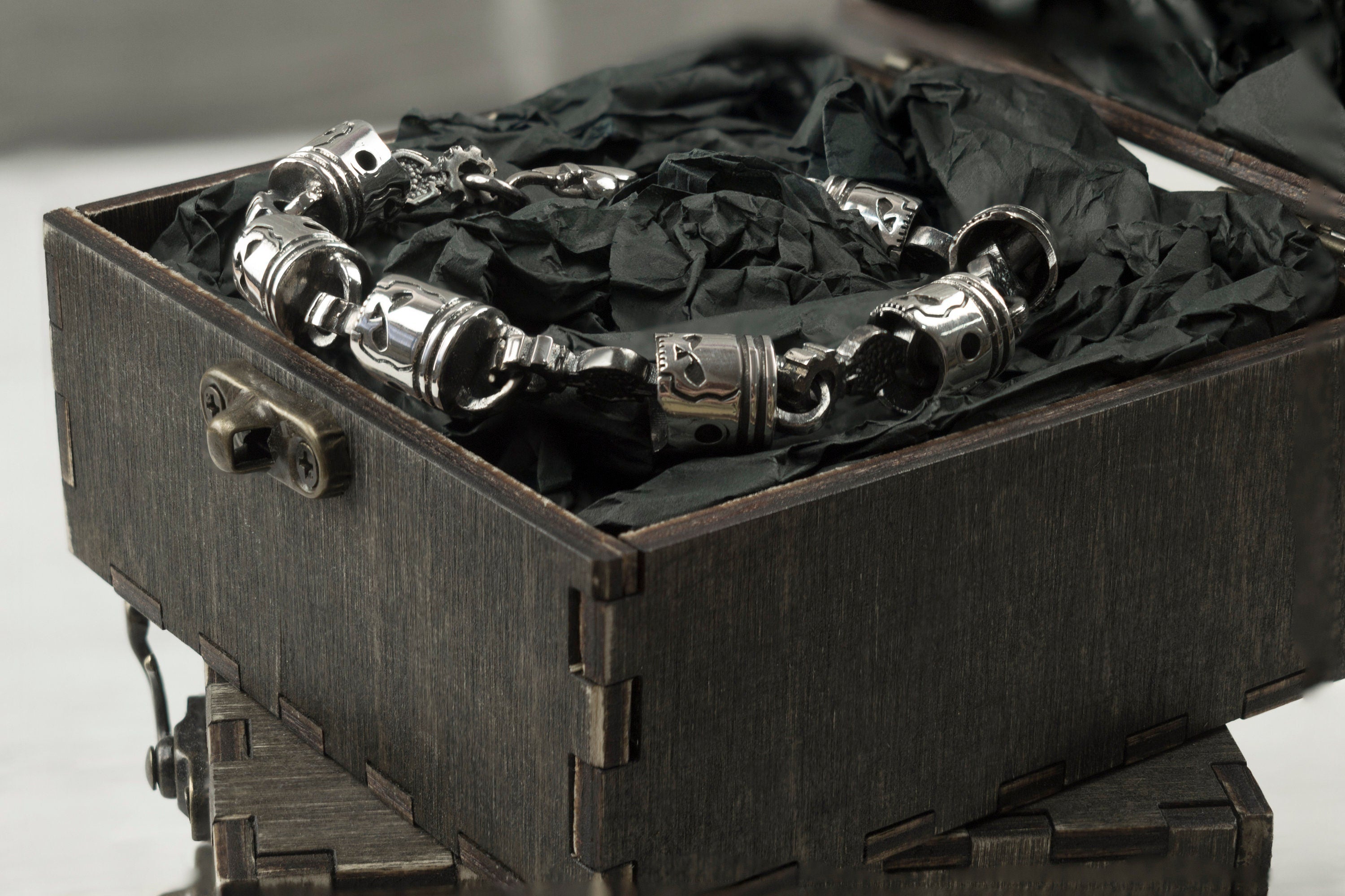 Piston and rod links of the skull bracelet inside a gift box, side view