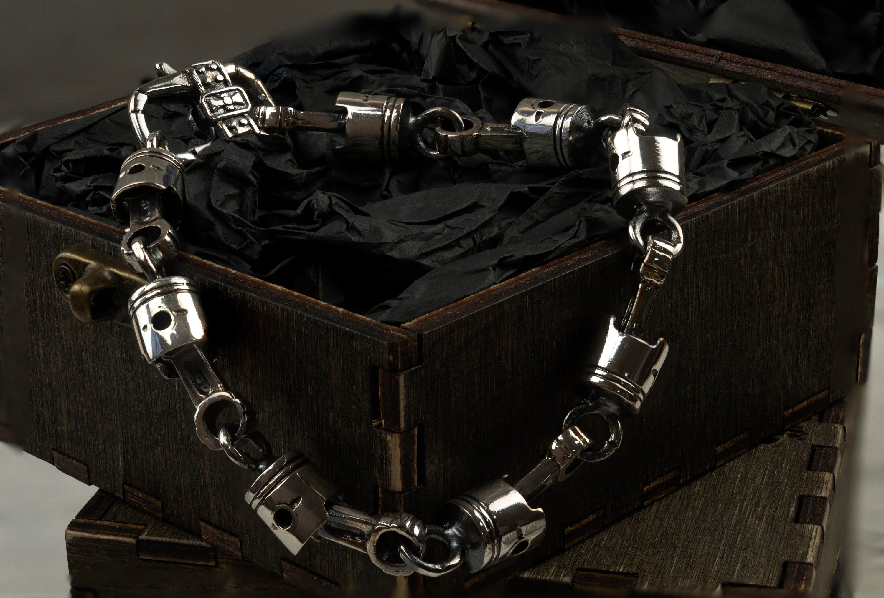 Close-up of cast skull pistons and connecting rods in oxidized 925 silver