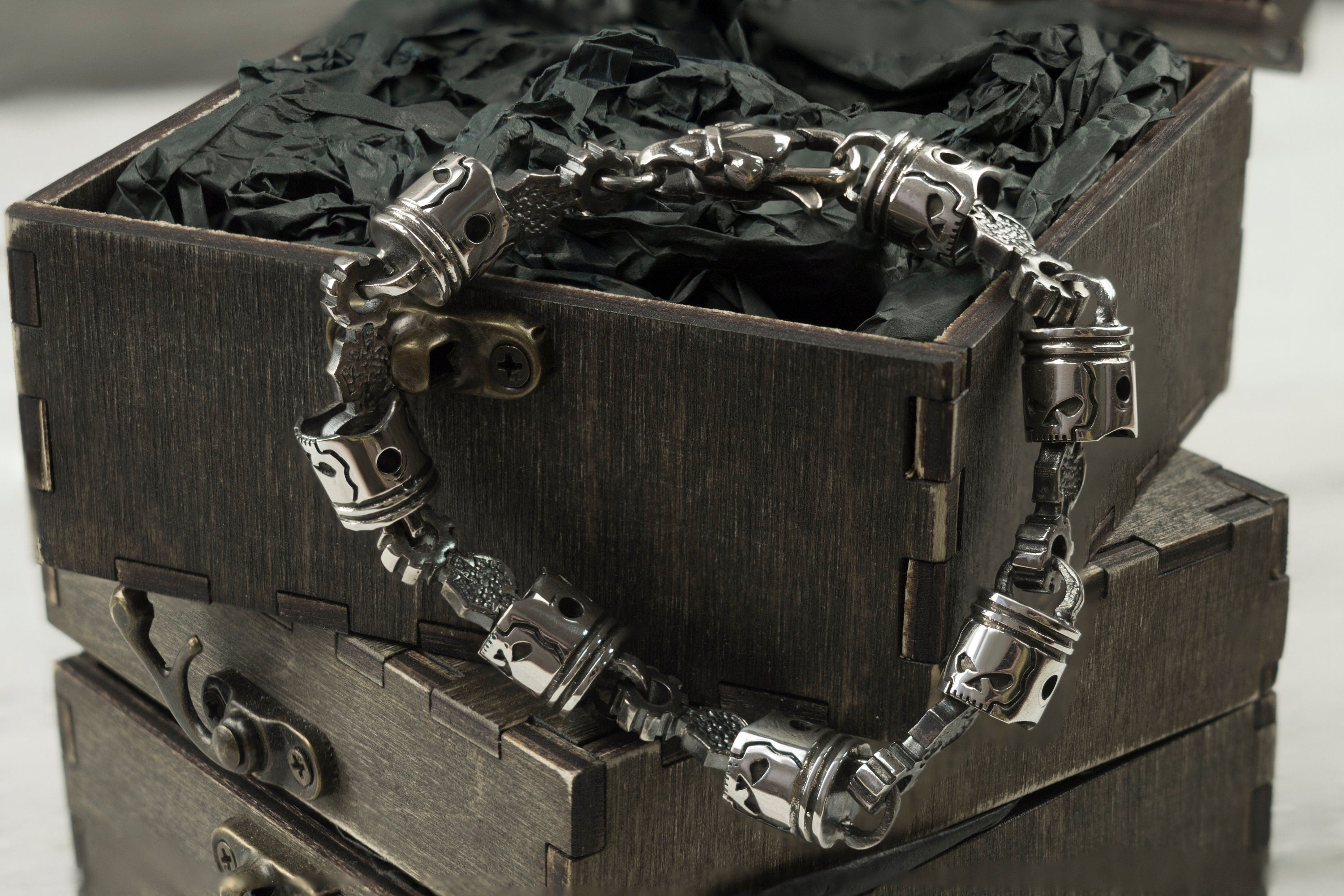 Men's mechanical silver bracelet with piston links on a box edge