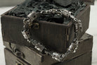 Men's mechanical silver bracelet with piston links on a box edge