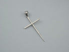Long sterling silver spike cross pendant with ribbed bail on a light background