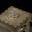 Tiny Frida sterling silver floral skull pendant with red stone eyes, on box