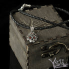 Tiny Frida sterling silver floral skull pendant with red stone eyes, on cord box