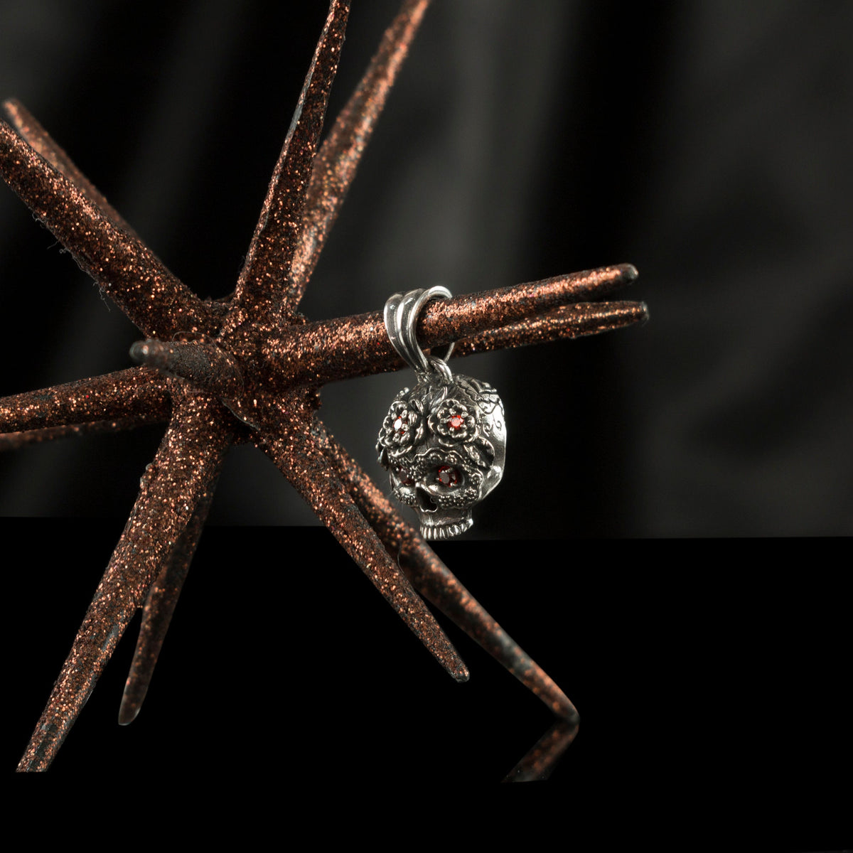 Tiny Frida sterling silver floral skull pendant with red stone eyes, with starfish close