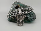 Vigor biker pendant lying on a heavy silver chain, top view