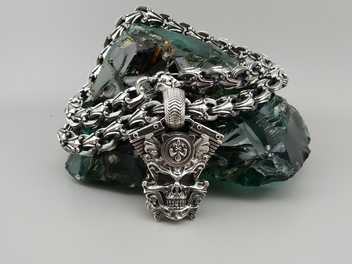 Vigor biker pendant lying on a heavy silver chain, top view