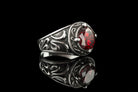 Viking signet ring angled view showing scrollwork shoulder and red stone