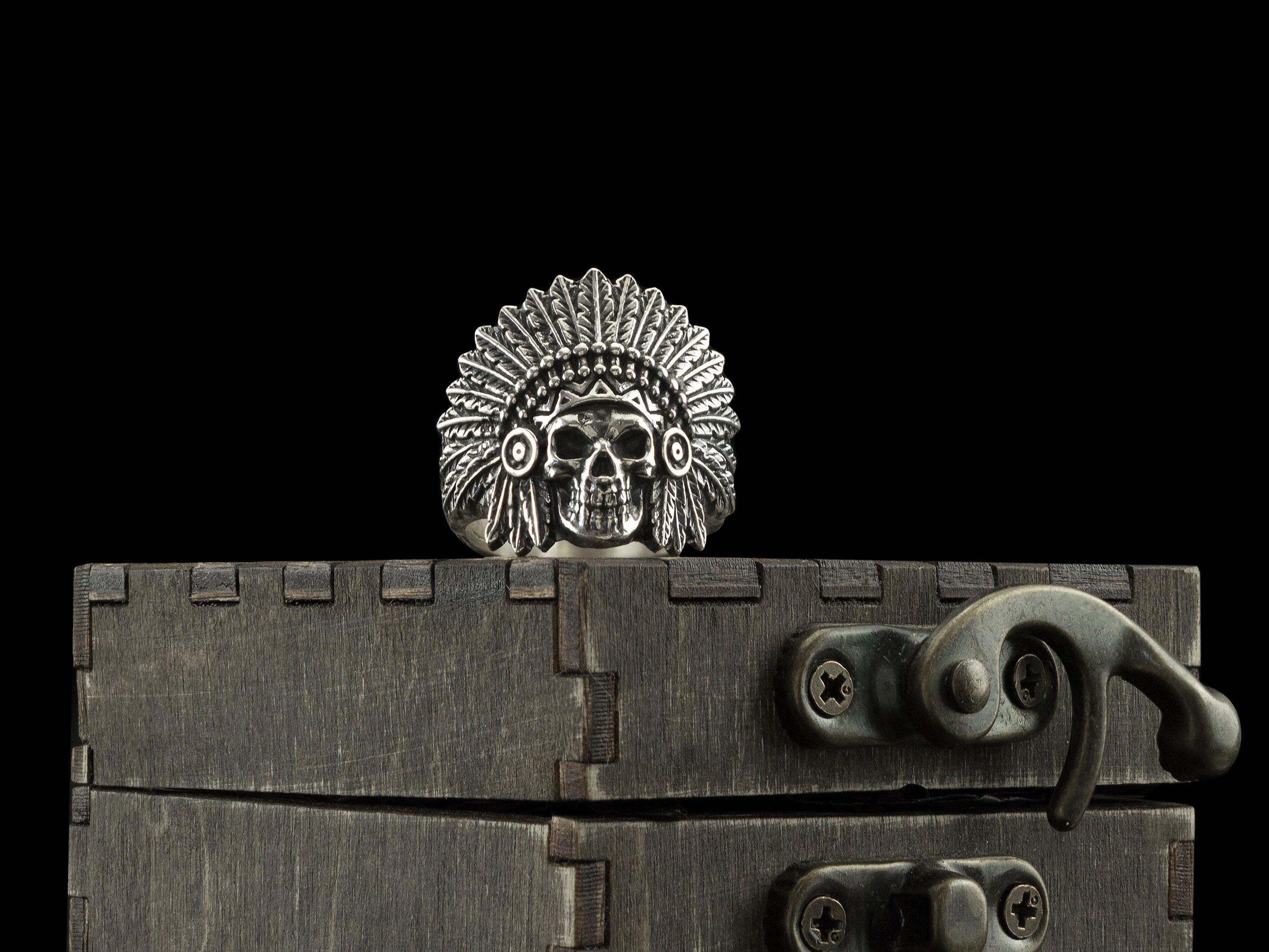War Bonnet skull ring with feathered chief headdress standing on a dark wooden box