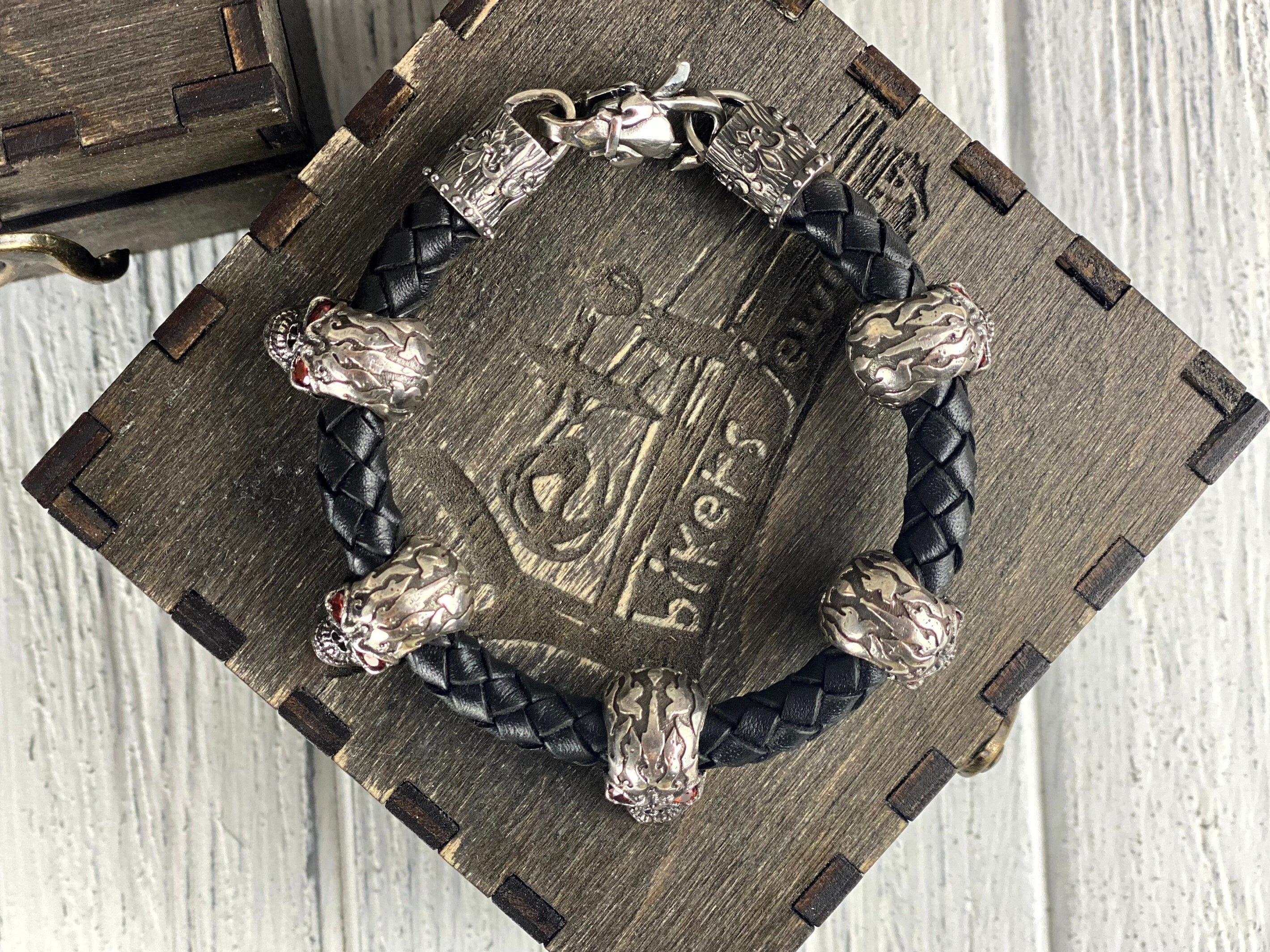 Wild leather skull bracelet coiled on a wooden box lid