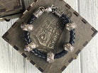 Wild leather skull bracelet coiled on a wooden box lid