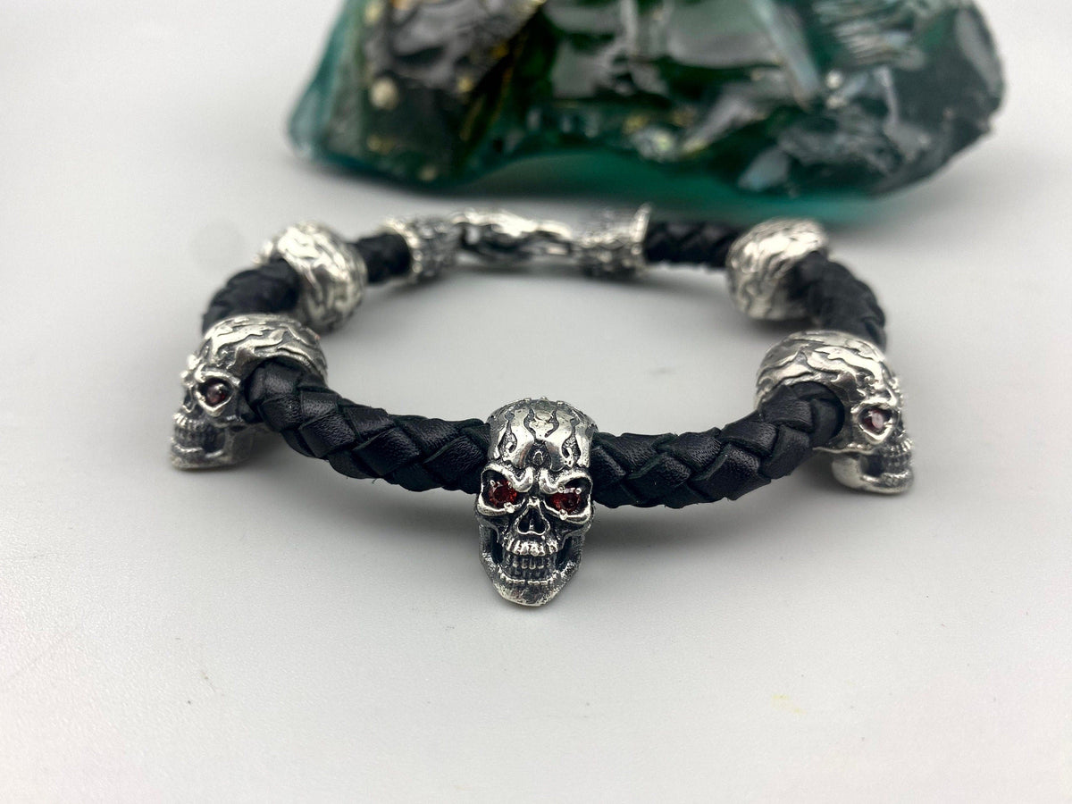 Wild skull bracelet with red-eyed silver skulls on braided black leather