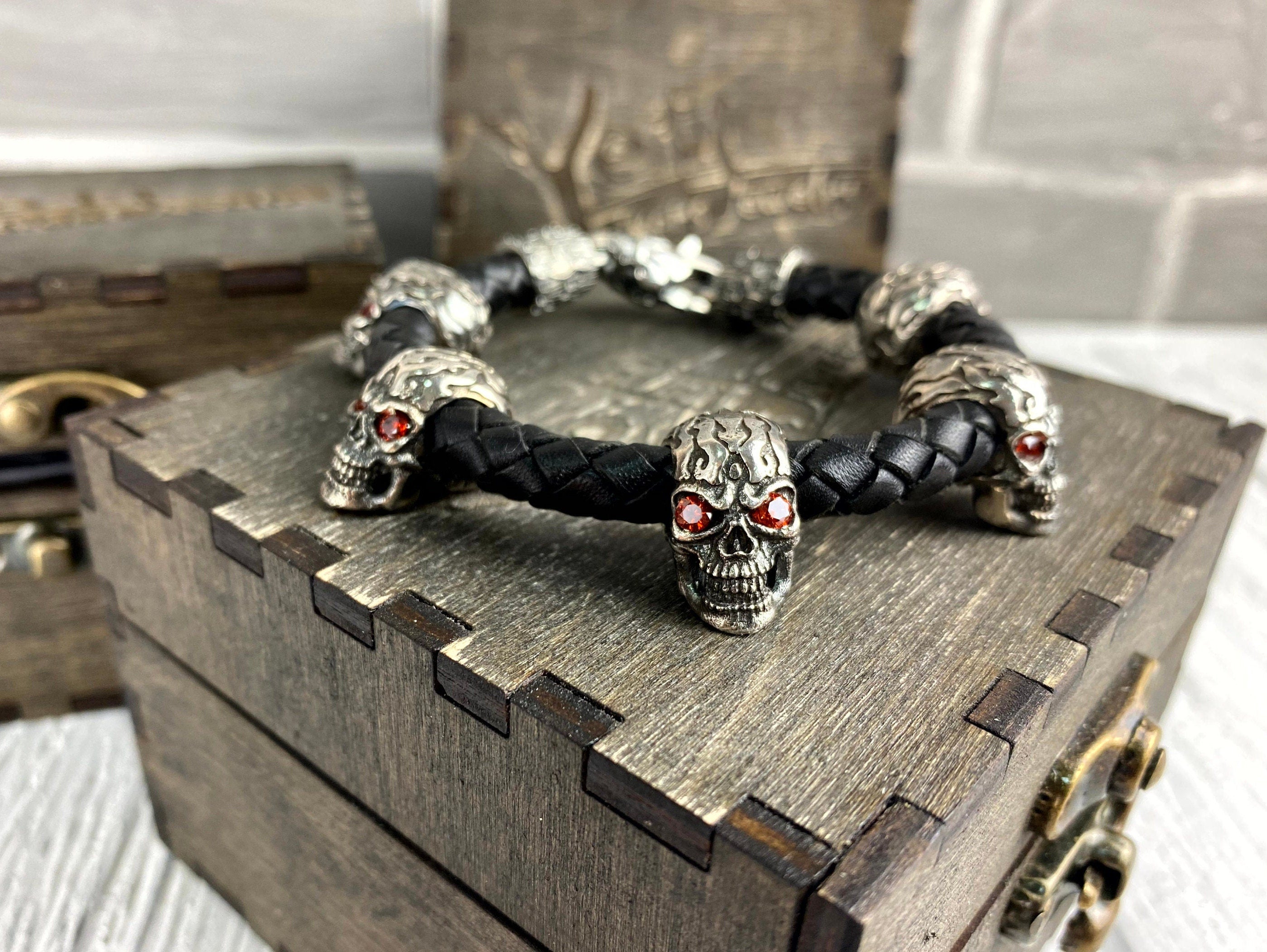 Wild red-eyed skull bracelet resting on a wooden gift box