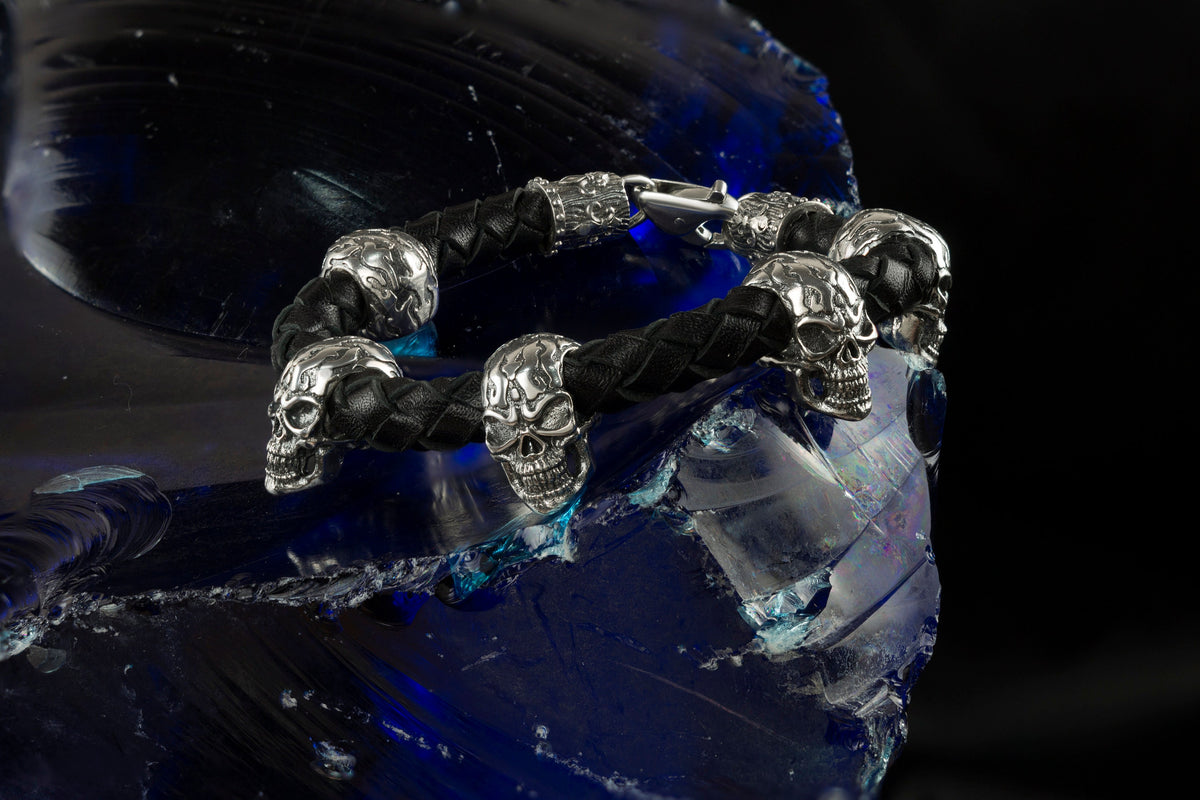Wild bracelet with sculpted sterling silver skulls on braided black leather