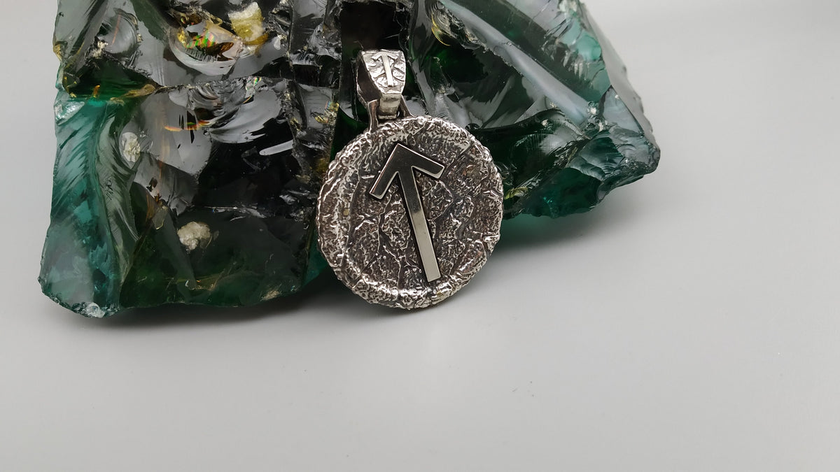 Round Norse rune pendant with Tiwaz arrow and heavy bail, angled view