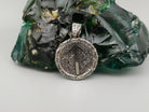 Round silver pendant with Tiwaz rune arrow on a textured oxidized background