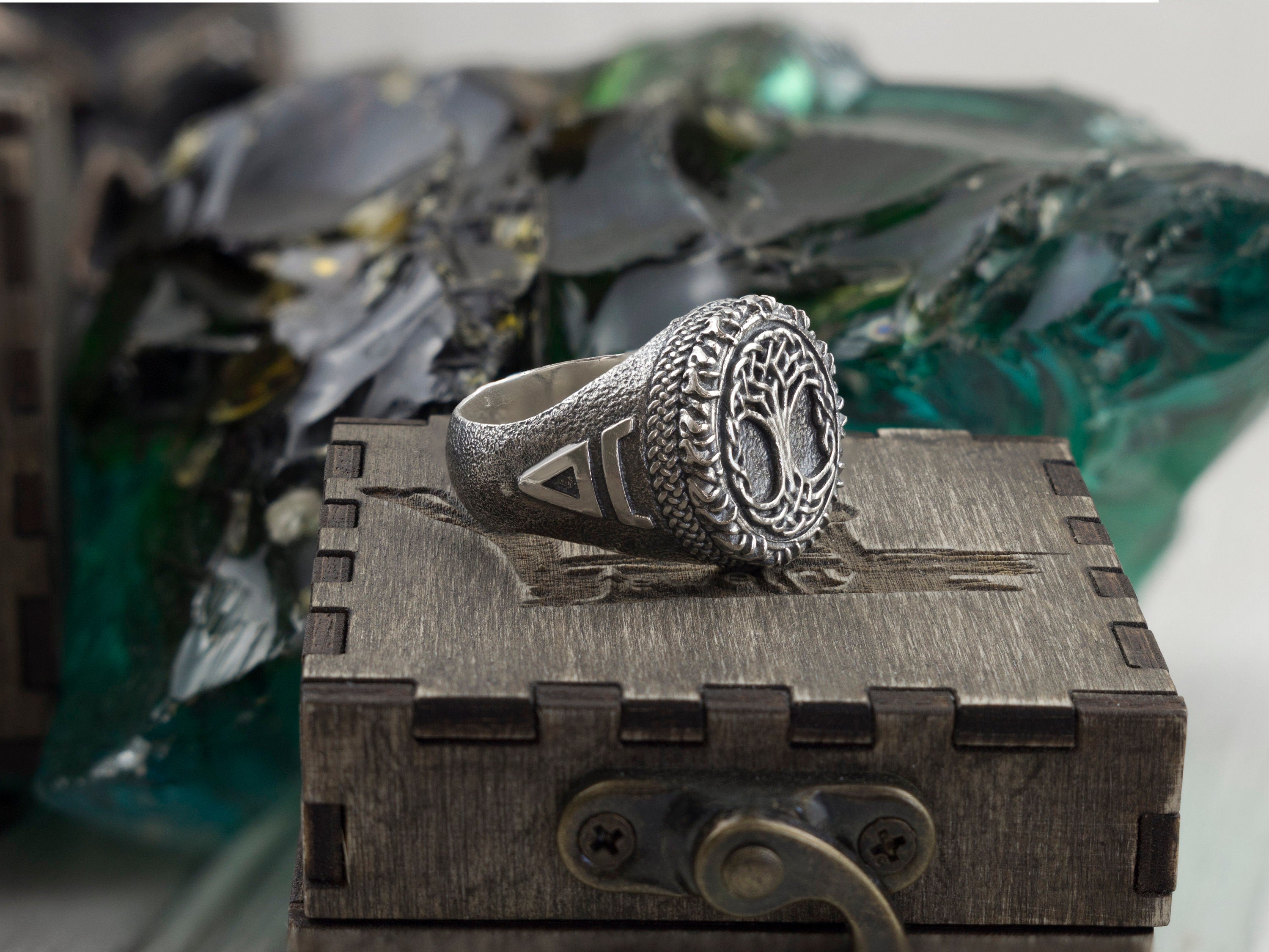 Heavy Tree of Life ring on a wooden box, three-quarter view