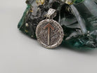 Close-up of the Tiwaz rune arrow on a round oxidized silver pendant