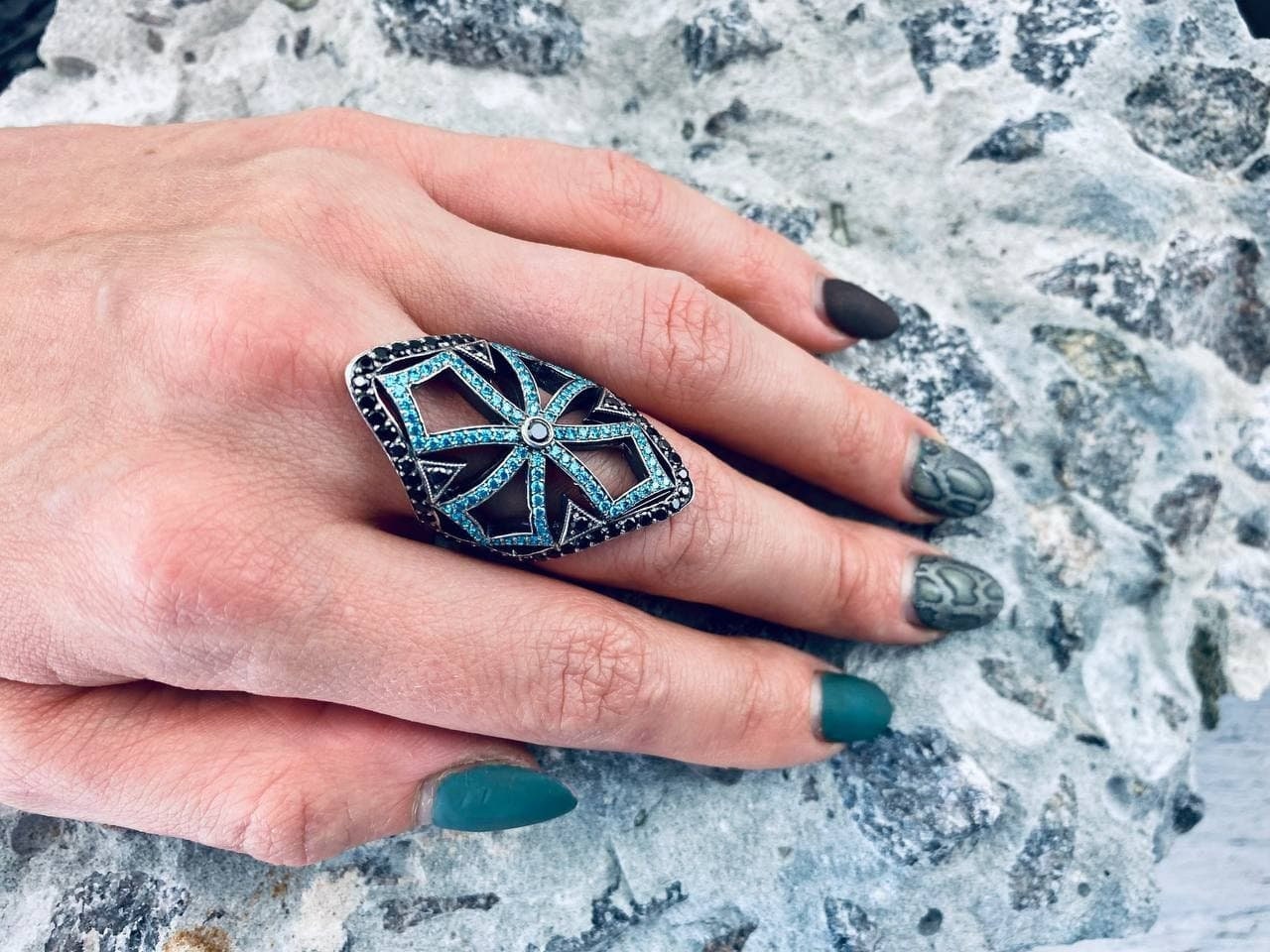 Queen of the Crusaders gothic silver armor ring with openwork cross and blue and black stones on a woman's hand