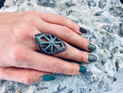 Queen of the Crusaders gothic silver armor ring with openwork cross and blue and black stones on a woman's hand