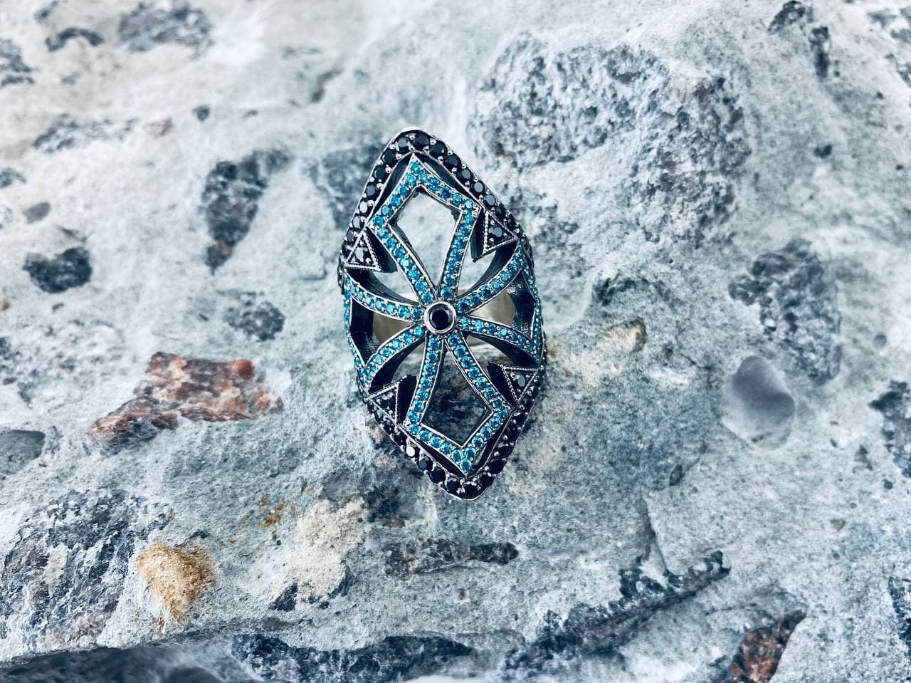 Close-up of the gothic silver armor ring with turquoise-blue and black cubic zirconia