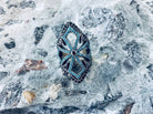 Close-up of the gothic silver armor ring with turquoise-blue and black cubic zirconia